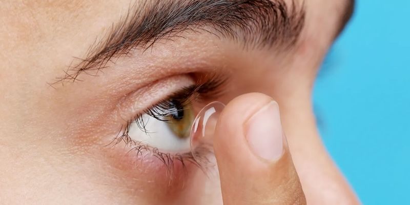 Man inserting contact lens